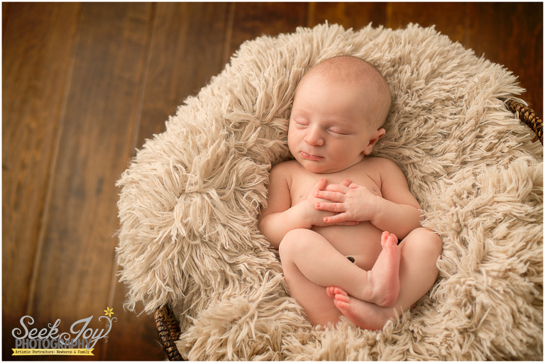 newborn boy laying in basket